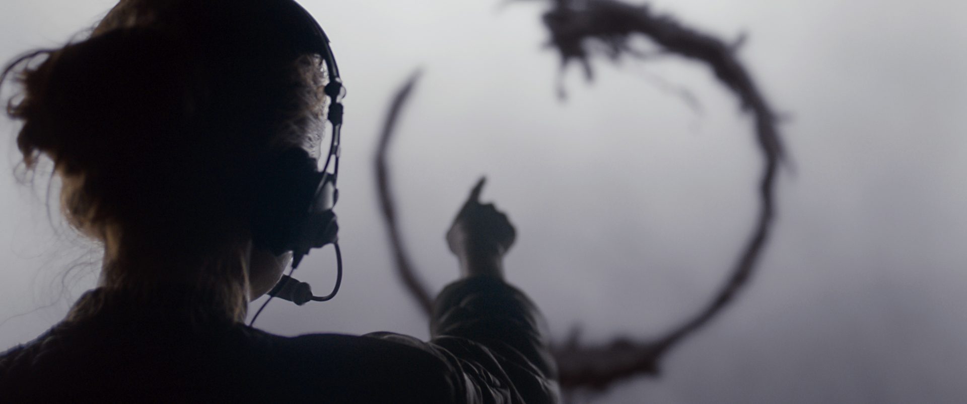 A scene from the movie Arrival, a character named Louise Banks is pointing towards an alien symbol