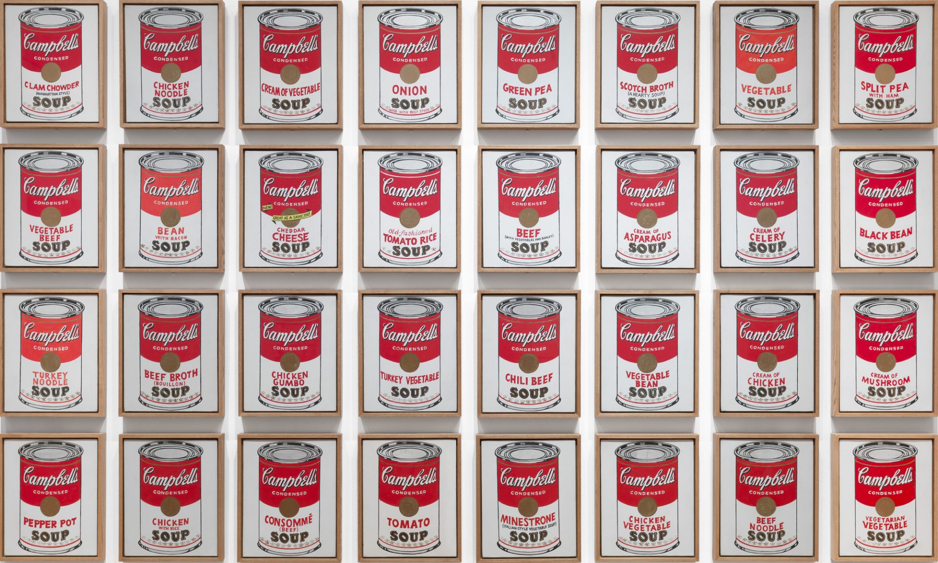 An array of 32 canvases, each featuring a different variety of Campbell's Soup cans. Each can is meticulously portrayed in red, white, and gold, mirroring the iconic packaging. Created by pop art pioneer Andy Warhol in 1962, this artwork showcases his exploration of consumerism and mass production.