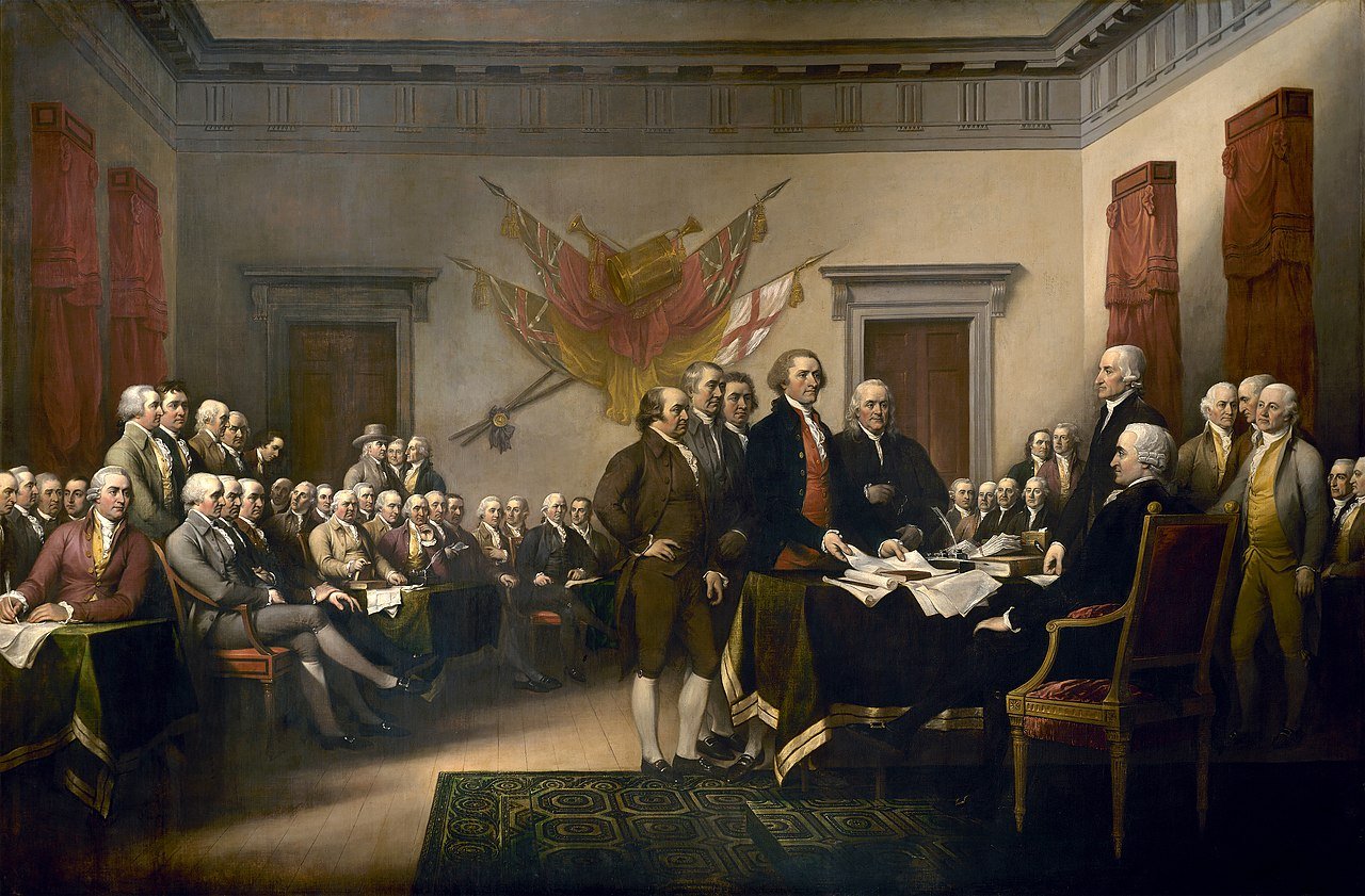 A large-scale oil painting by John Trumbull titled “Declaration of Independence”, displaying historical figures gathered around a desk presenting the draft of the declaration to Congress, with individual details richly captured. This iconic artwork, filled with nuances and historical storytelling, stands as a testament of a pivotal moment in American history.