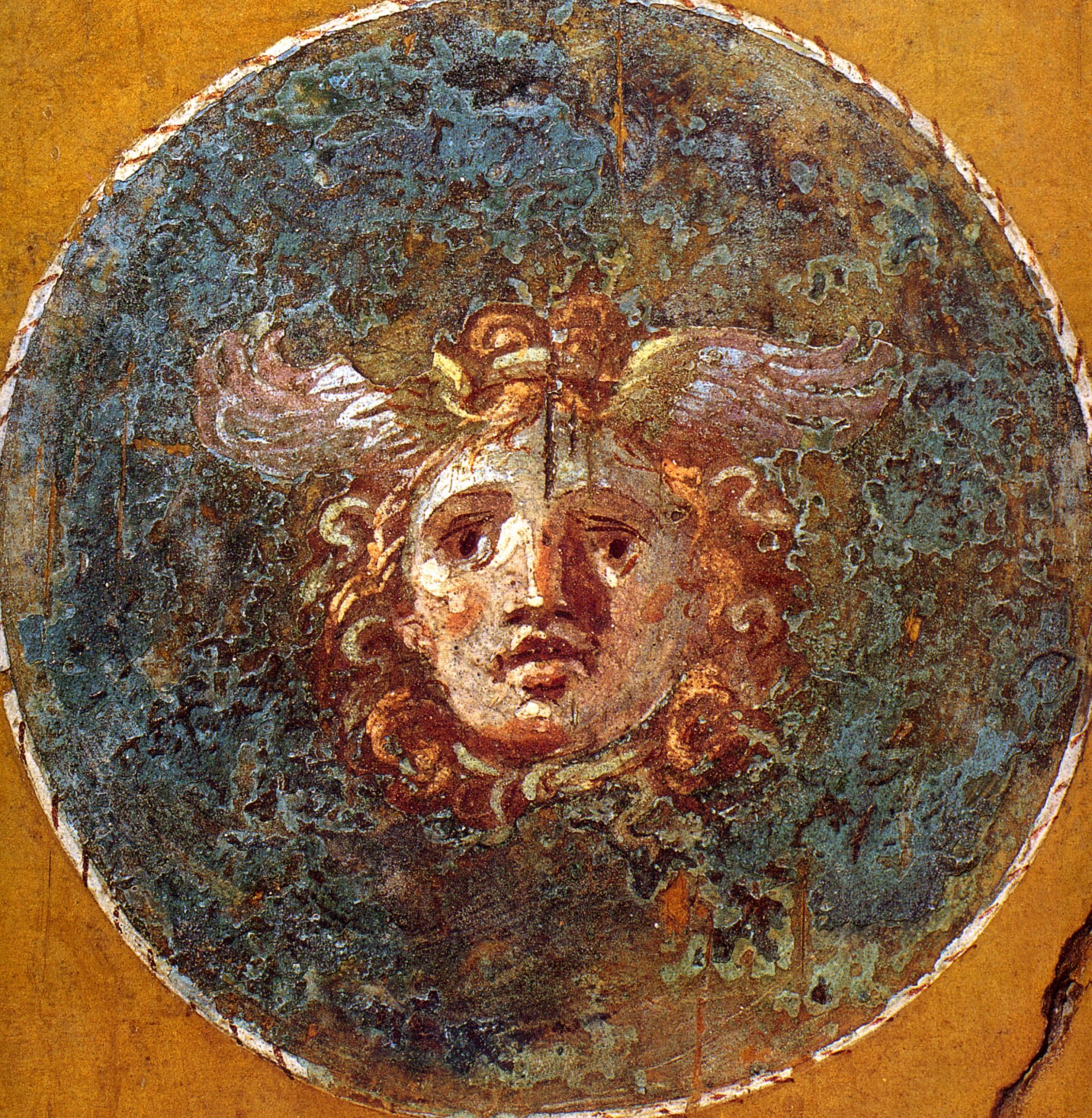 A roman fresco painting of a Gorgon face in a circle
