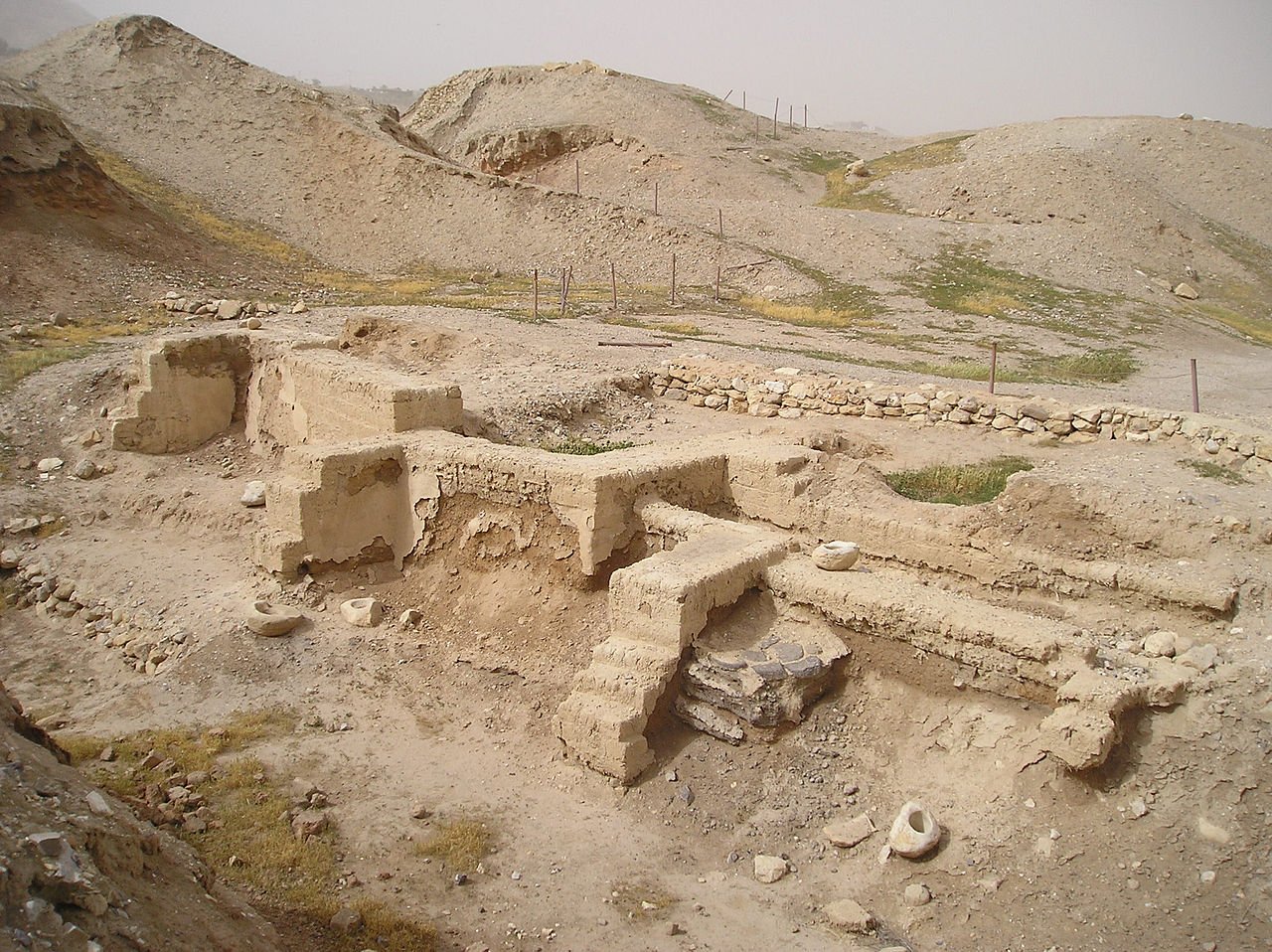 A photograph of ancient ruins of a house in a desert-like setting.