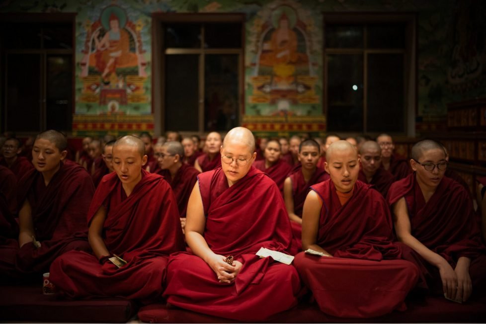 Female Buddhist nuns wearing maroon robes.