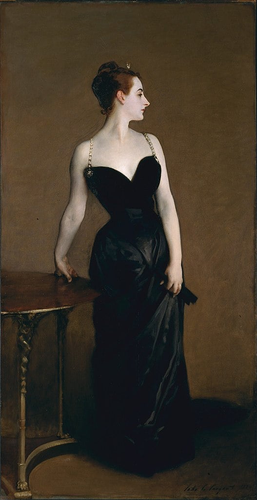 A striking portrait of Madame Pierre Gautreau, also known as Madame X, by John Singer Sargent. She's showcased in a sleek black dress with a plunging neckline. Her alabaster skin offers a stark contrast to the rich, dark backdrop and her dress.