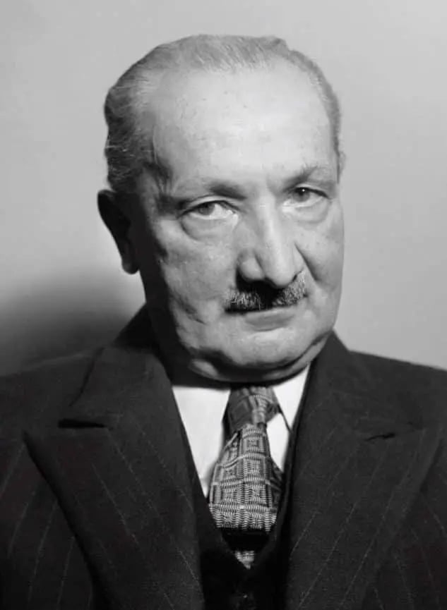 A black and white portrait of Martin Heidegger.