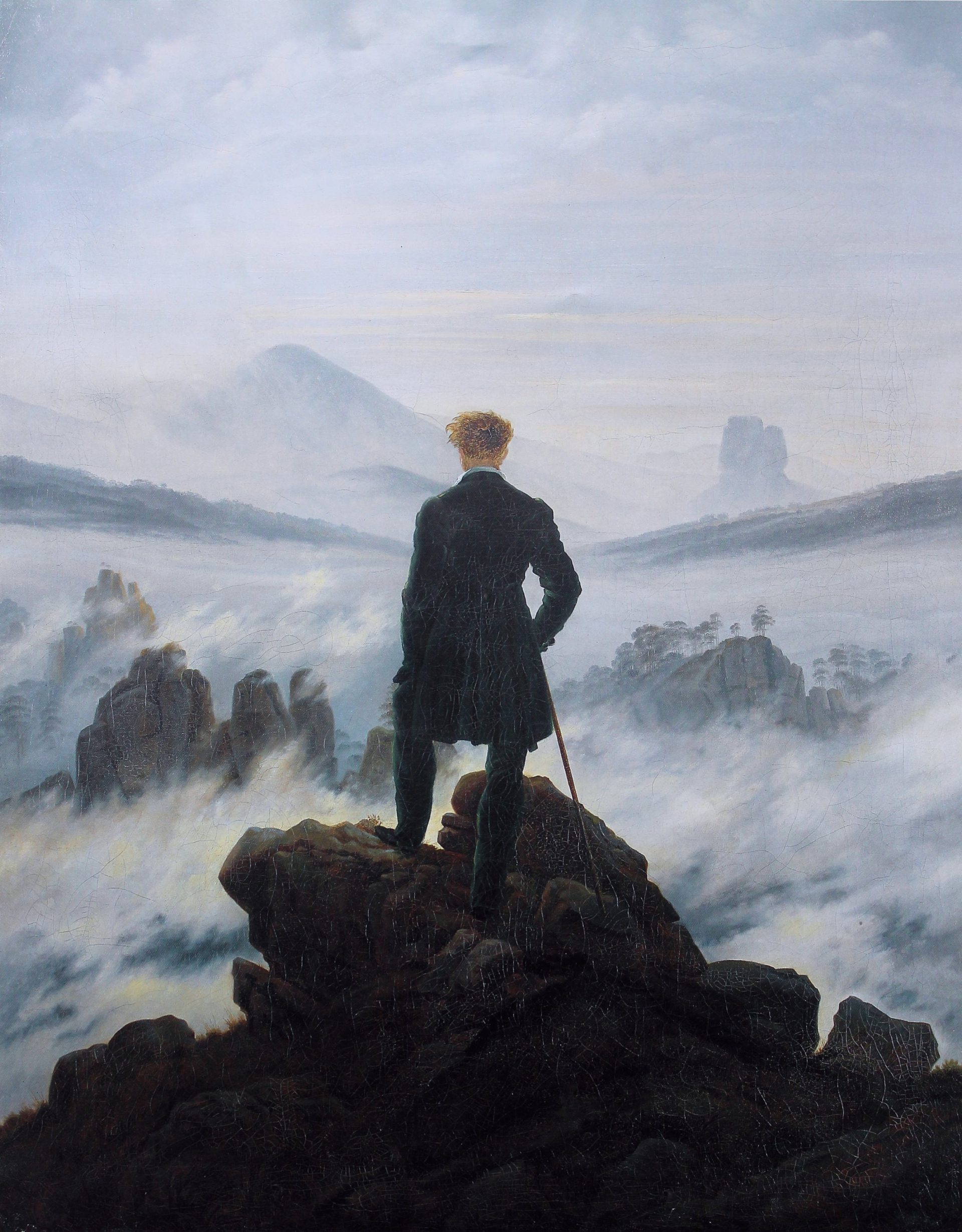 A painting of a male figure standing at the edge of a cliff, staring into a large foggy valley.