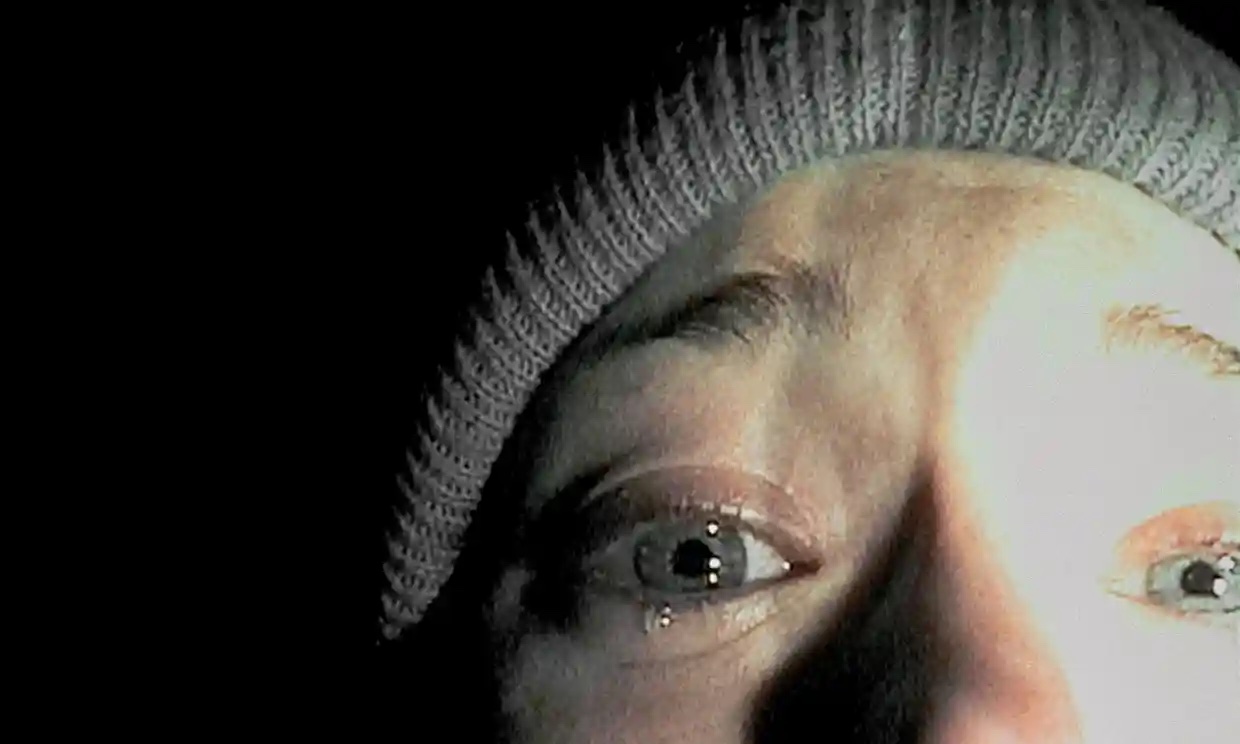 A crying woman staring into the camera, half of her face is seen.