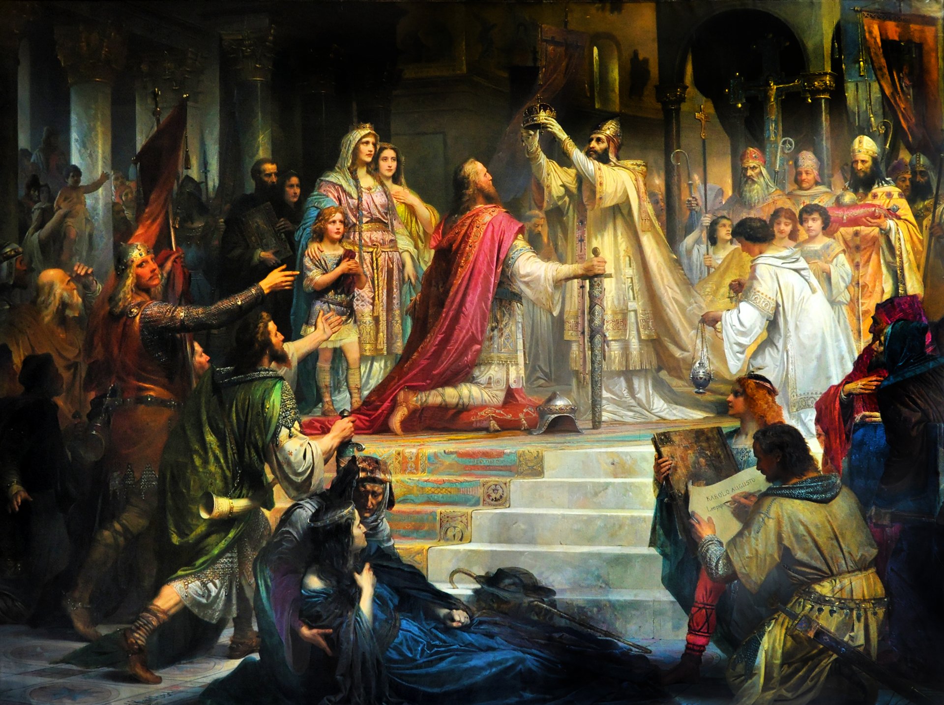 Historic painting depicting the coronation of Charlemagne as Emperor. In a grand cathedral setting, Charlemagne, dressed in regal red robes, kneels reverently. A Pope Leo III, adorned in ornate golden vestments, raises a crown above Charlemagne's head. Surrounding them, various onlookers, including knights, clergy, and nobles, witness the momentous occasion.