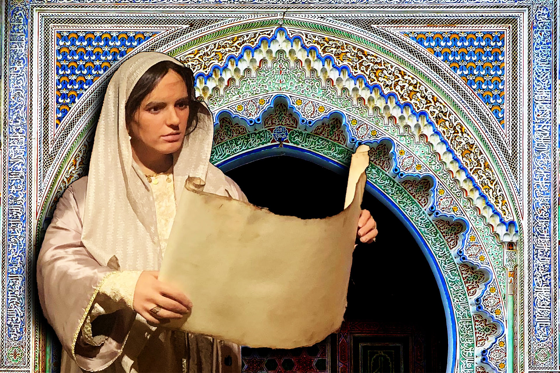 A museum exhibit of a Fatima Al-Fihri mannequin in a white robe holding a parchment scroll in front of a blue and white tiled archway.