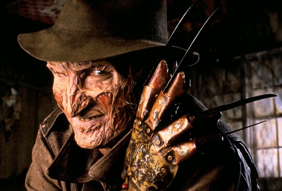 An image of a badly burned man, wearing a glove with knives sticking out of each finger.