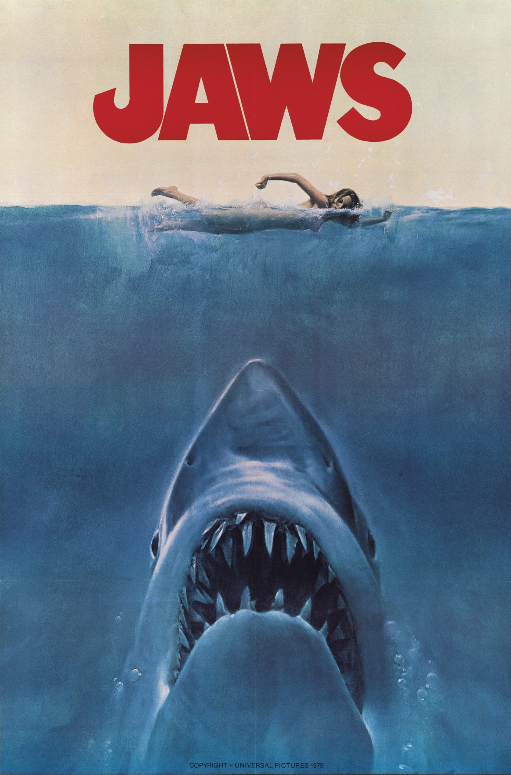 A film poster featuring a giant shark about to attack a swimming woman.