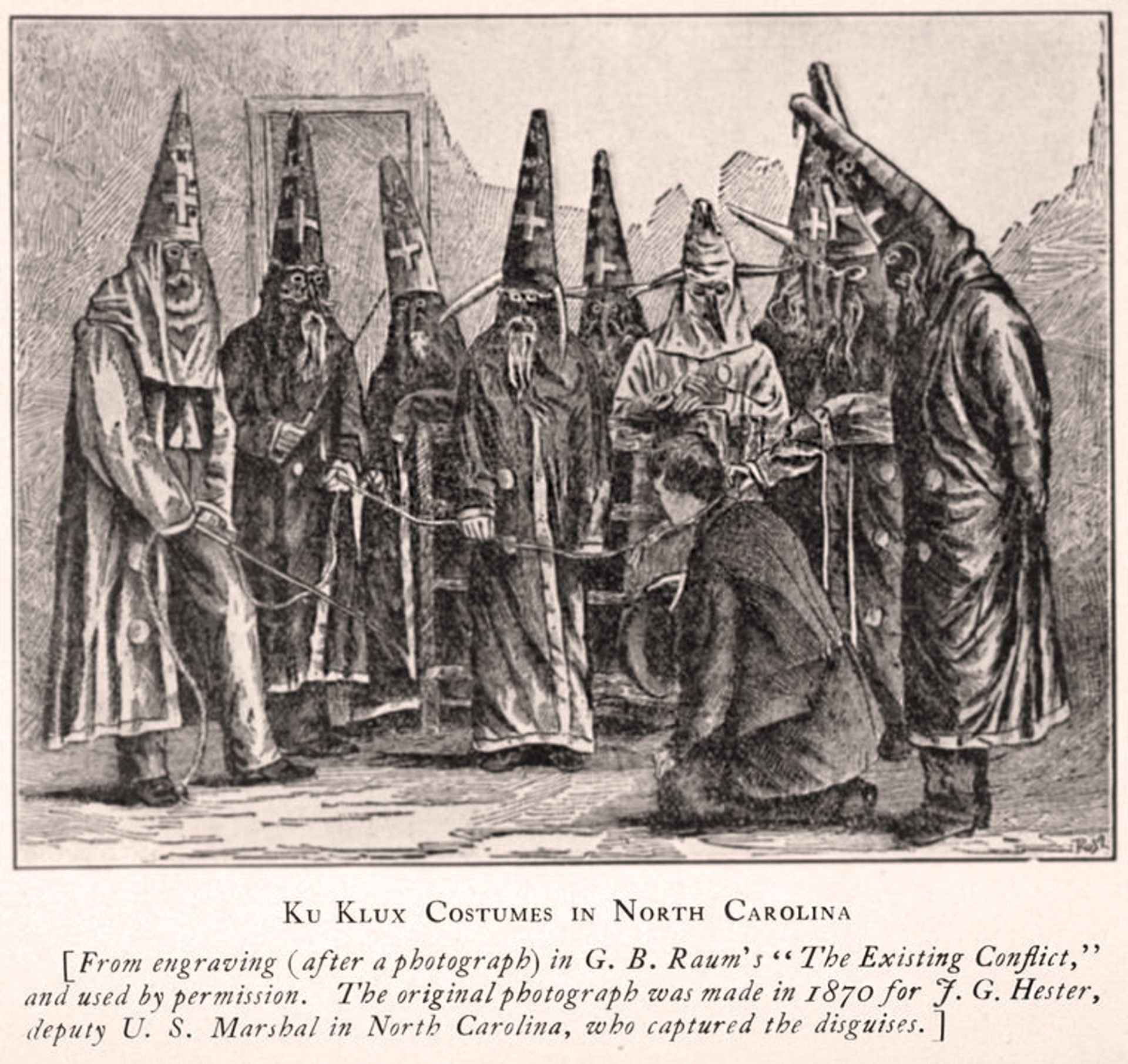 A group of people in Ku Klux Klan costumes in North Carolina, 1870. The costumes are long robes and pointed hats with eye holes. The image is an engraving based on a photograph.