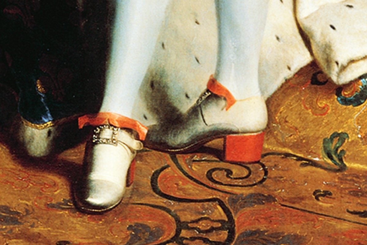 A close up of a painting of Louis XIV focusing on his white shoes with large red heels and a gold buckle.