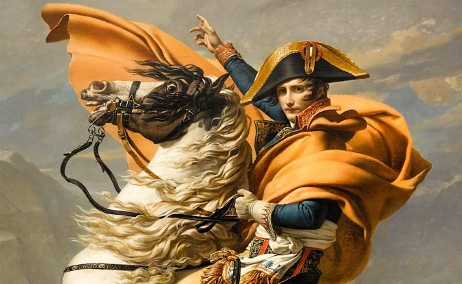 Dramatic painting of Napoleon Bonaparte mounted on a rearing white horse, ascending a rugged alpine landscape. Napoleon, adorned in a vibrant red cape, confidently points upwards while turning to look at the viewer.