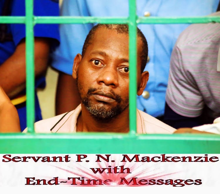 Paul Mackenzie looking at the viewer through green bars as he is being held in custody. At the bottom of the image the logo of the cult Good News International Church reads “Servant P.N. Mackenzie with End-Time Messages”.