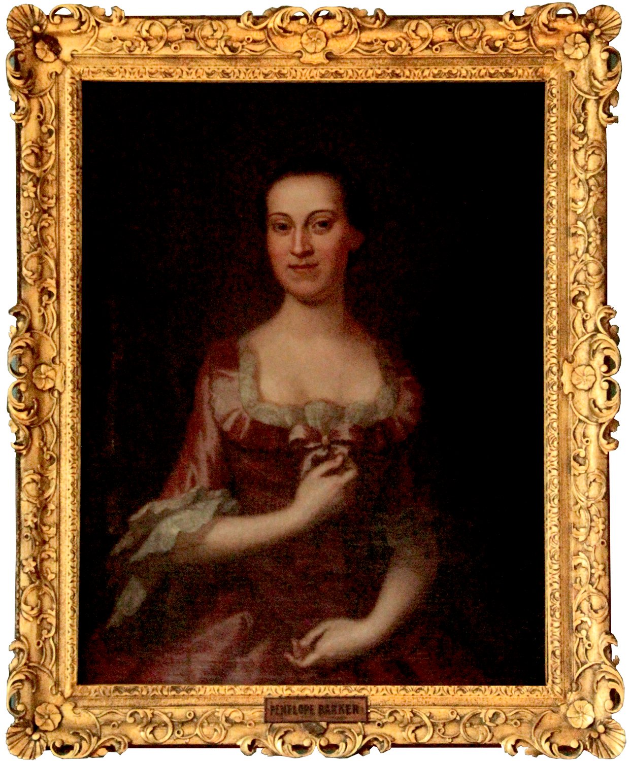 A painting in an elaborate gold frame of a smiling woman in an 18th century red dress.