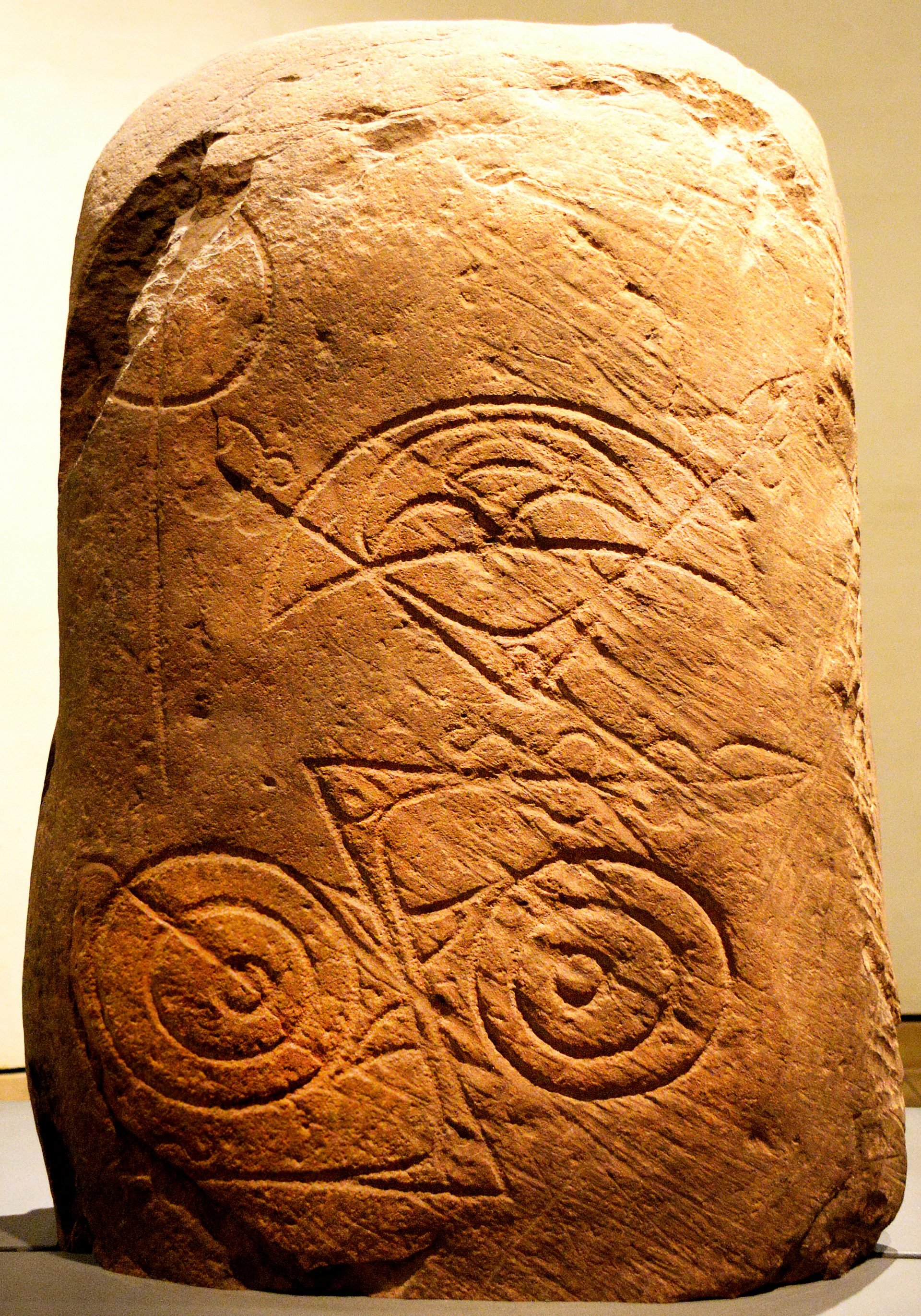 A stone engraved with Pictish symbols from the 7th and 8th century CE, featuring double-disc, crescent, and z- and v-shapes. The exact significance of these symbols remains historically unclear.