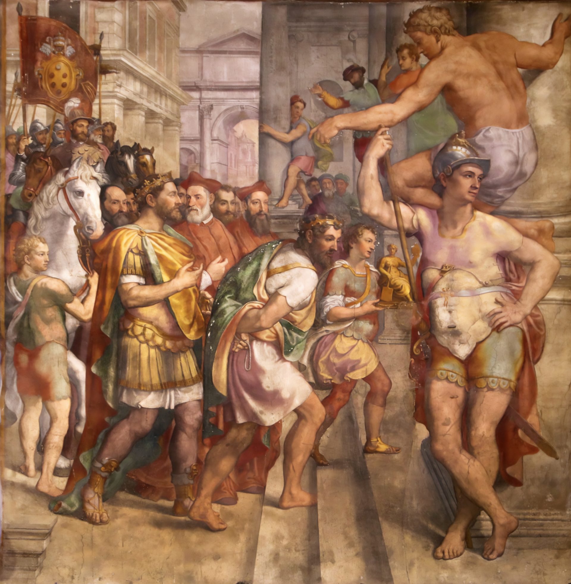 A painting of Pepin the Short donating reclaimed lands to Pope Stephen II in 756. The painting shows Pepin, wearing a crown. Behind them are several men, some on horseback, wearing various colors and styles of clothing. The background depicts a city square with classical buildings.
