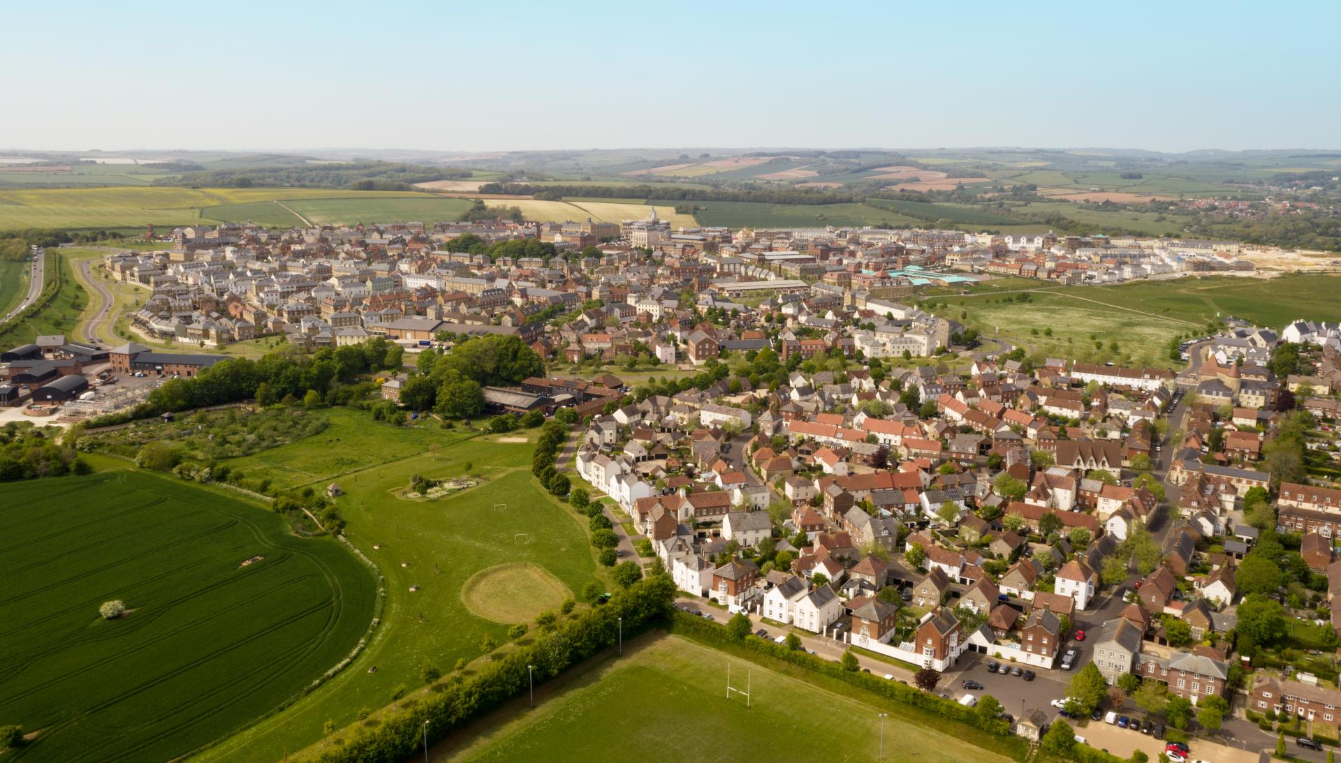 An aerial photograph of a small English town surrounded by green fields.