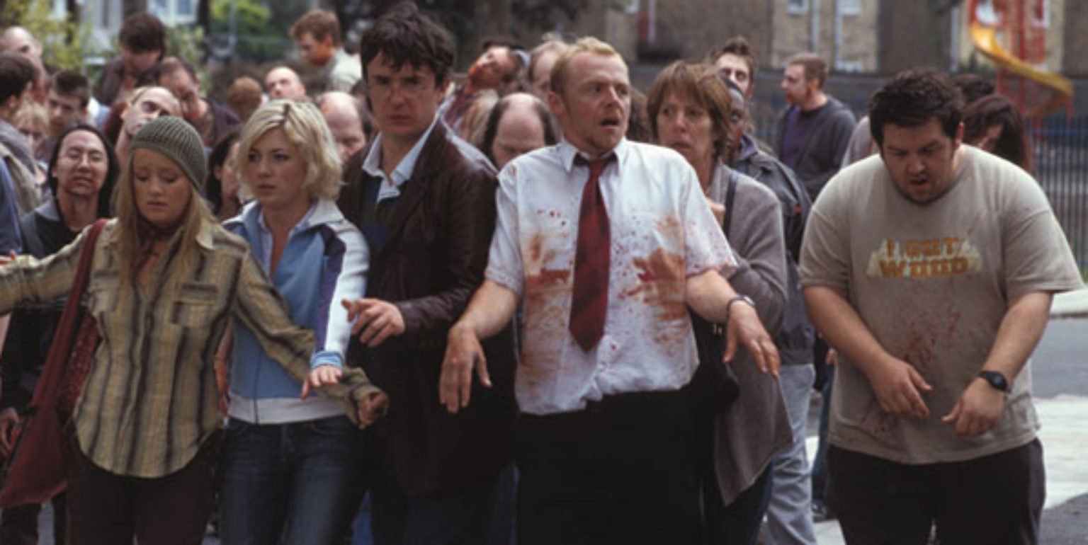 A group of people looking distressed, one of them is covered in blood.
