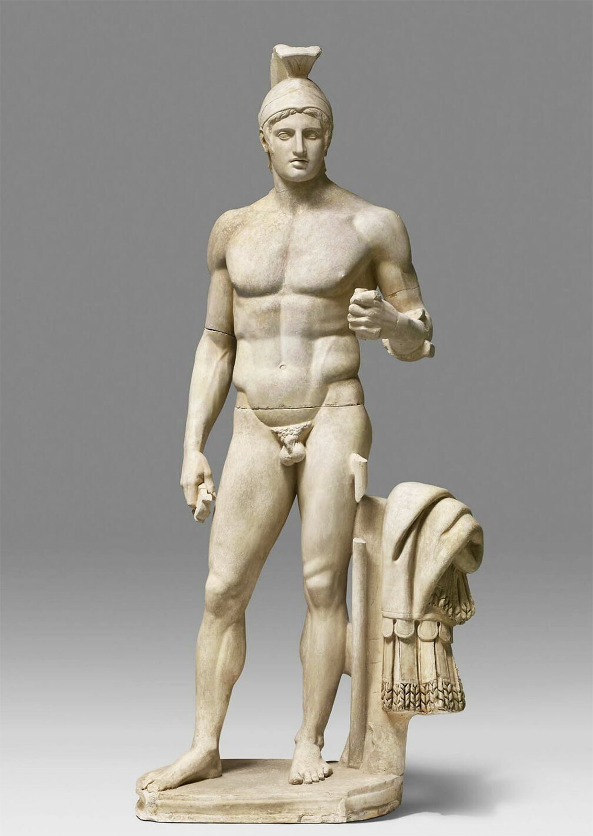 Classical statue depicting Ares, the Greek god of war, in a standing pose with a helmet and muscular physique. The statue is a Roman replica based on a 5th century BC Greek original.