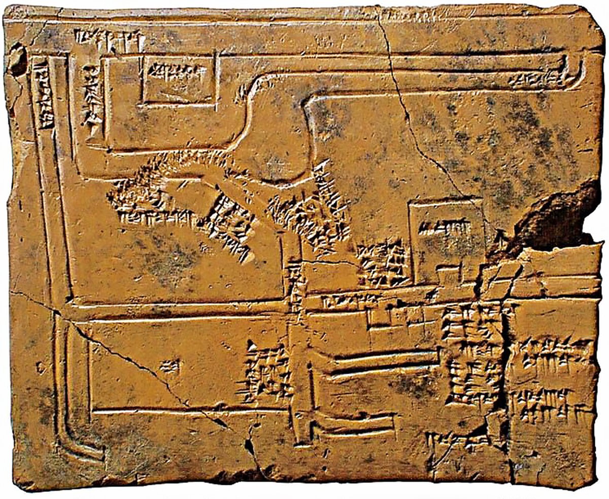 An ancient clay tablet with cuneiform writing on a light beige background. The tablet is rectangular in shape and has a large crack on the right side. The cuneiform writing is in the form of small triangles and lines. The writing is arranged in rows and columns and also shows a map of canals and irrigation systems.