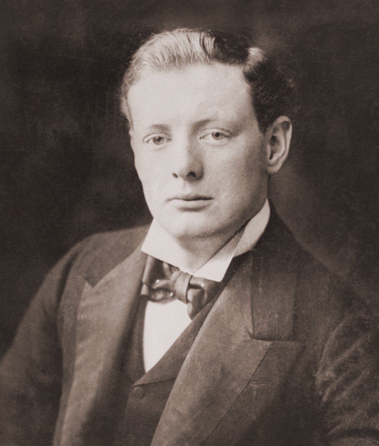 A half-length portrait from 1900 showcasing a young Winston Churchill, dressed in formal attire, exuding confidence and determination.