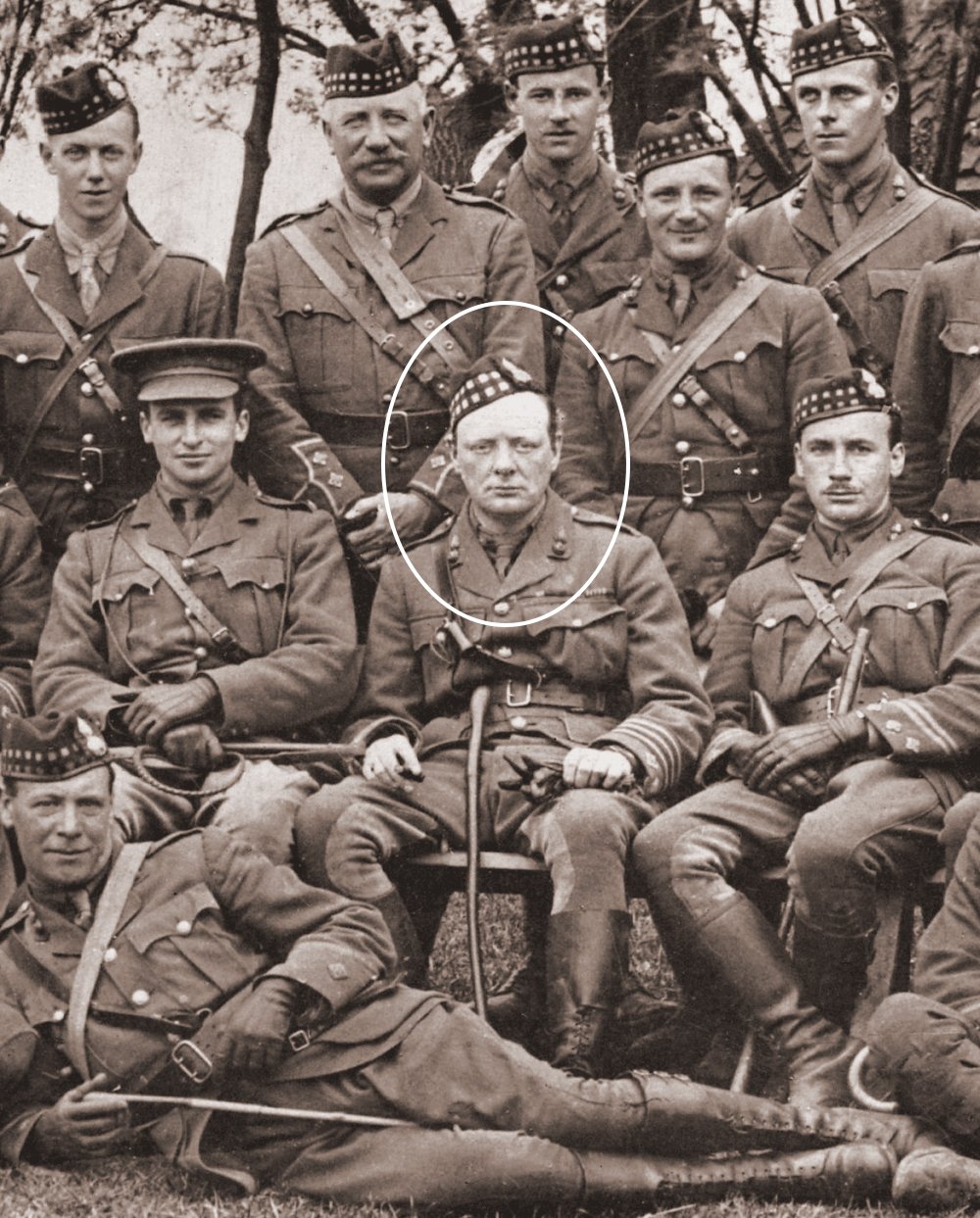 Vintage photograph of a group of soldiers in uniform, with Winston Churchill highlighted in the center by a circle. Churchill is seen wearing a military cap and uniform, commanding the 6th Battalion, the Royal Scots Fusiliers, in 1916.