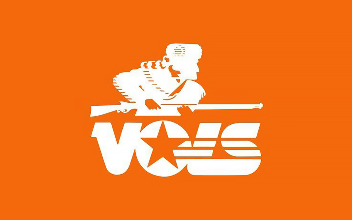 An orange background features a white silhouette of Davy Crockett in his iconic coonskin hat, holding his rifle over the word 'VOLS' in bold white letters. The design is inspired by Davy Crockett, serving as the Tennessee Volunteers' 1983 logo