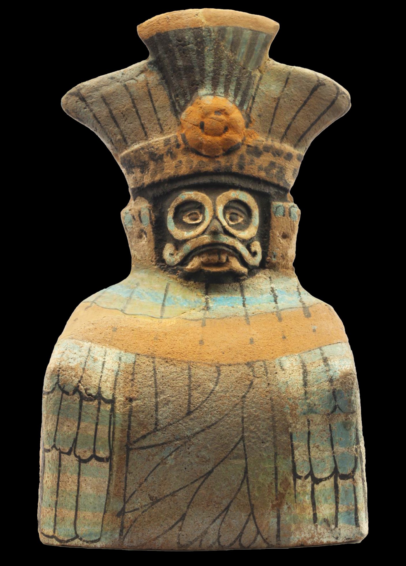 Ancient Toltec figurine featuring a detailed face with prominent eyes and mustache, wearing a large headdress with a central orange ornament. The pottery figure has intricate patterns and faint blue and brown hues.