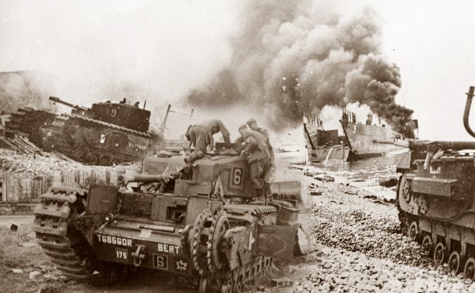 Sepia-toned historical photograph showing the chaotic scene of the Dieppe Raid with a "Churchill" tank marked with the number 6 in the foreground, and another tank number 9, amid smoke from a burning Landing Craft, Tank (LCT) in the background, illustrating the intense battle and strategic challenges faced during the operation.