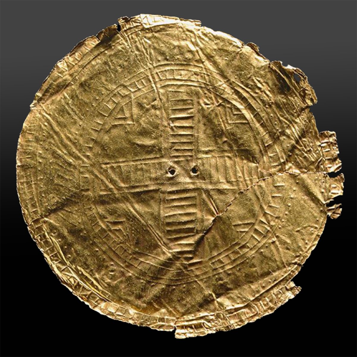 An ancient gold disc with embossed geometric patterns, identified as the Druid Sun Disc from Ballyshannon, Ireland, dated between 2500–2150 BC.
