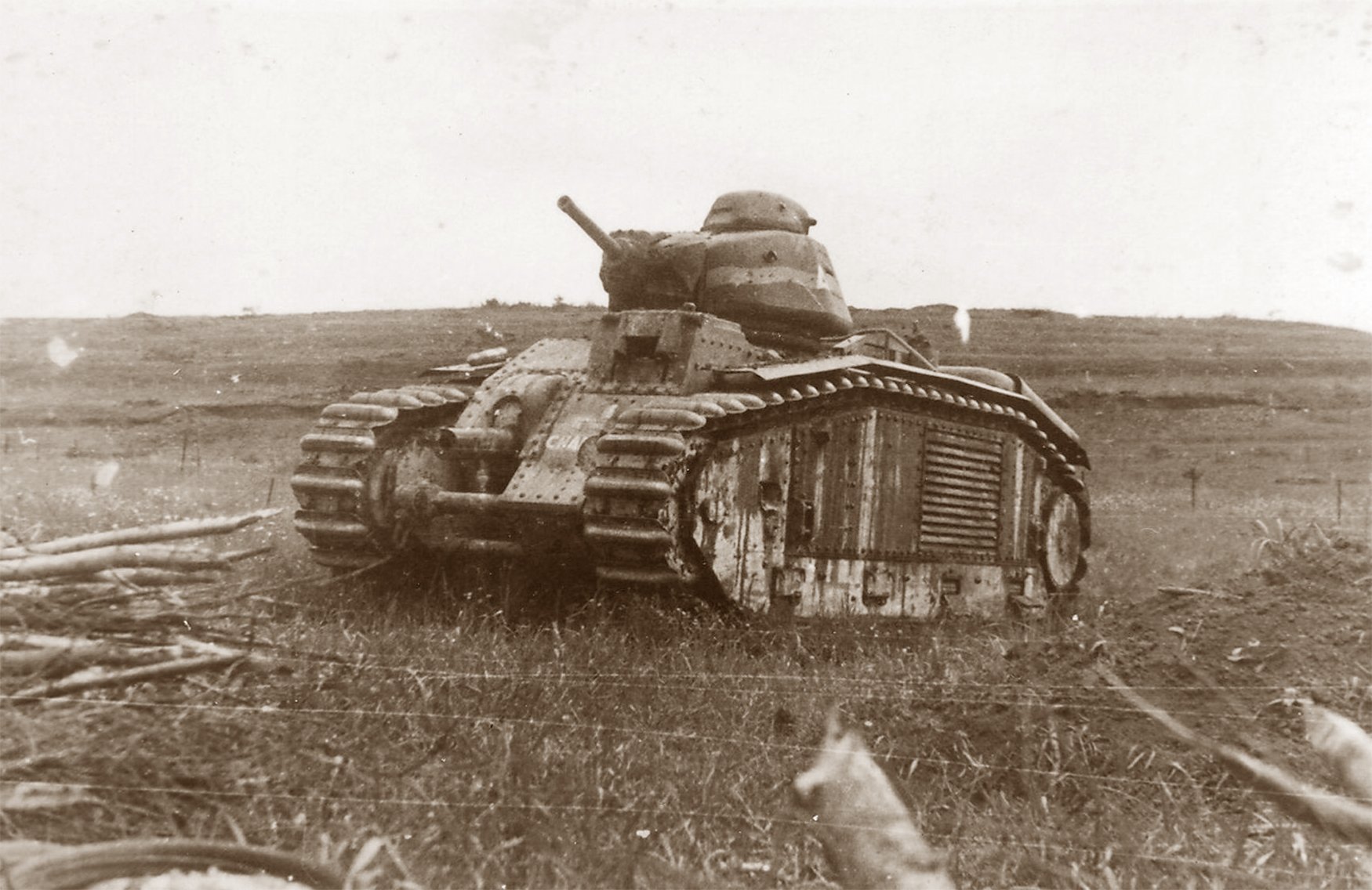 A black and white photograph of the French Char B1 bis tank "CHARENTE" from World War II, shown abandoned in an open field with its imposing form and battle damage, symbolizing the intense conflict of the era.
