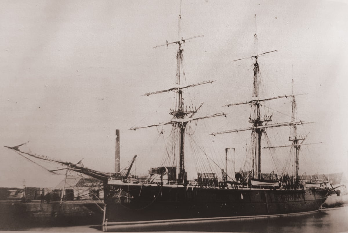 A sepia-toned historical photograph of the ironclad corvette "Ryūjō" docked at a port, showcasing its mast.