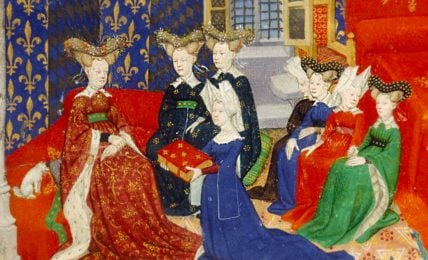 A detailed medieval painting depicting six women adorned in lavish dresses and headdresses, seated in an ornate chamber with patterned walls. The women are portrayed in various poses: some converse with each other, while one presents a decorated book. The vibrant colors of their garments, including deep reds, blues, and greens, are accentuated by intricate patterns and golden accents.