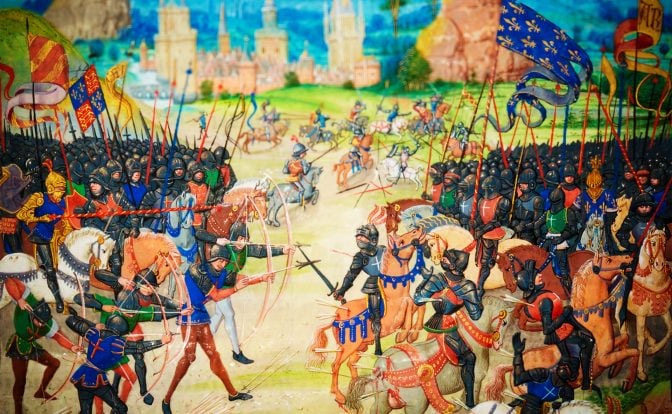 Image from an illuminated manuscript depicting a medieval battle scene, likely representing one of the historic clashes such as Crécy, Poitiers, or Agincourt, where English and French forces engaged. The foreground features English longbowmen actively shooting, while armored knights on horseback and soldiers engage in combat. The background showcases a detailed landscape with castles, rocky cliffs, and a bright blue sky, capturing the intensity and pageantry of the Hundred Years' War era.