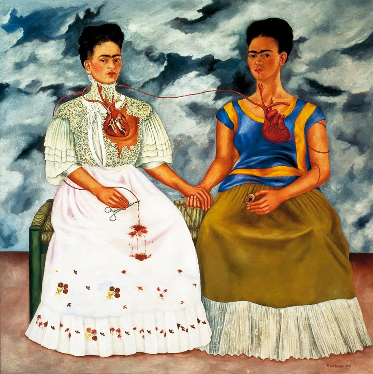 This image is a painting titled "The Two Fridas" by Frida Kahlo from 1939. It depicts two versions of the artist sitting side by side, with their hearts exposed and connected by a vein. The Frida on the left is dressed in a white European-style Victorian gown while the Frida on the right wears a traditional Mexican dress. The sky behind them is tumultuous, with swirling dark clouds, suggesting emotional turmoil. The exposed hearts and the blood vein, which one Frida cuts with scissors, symbolize the pain and divided identity experienced by the artist.