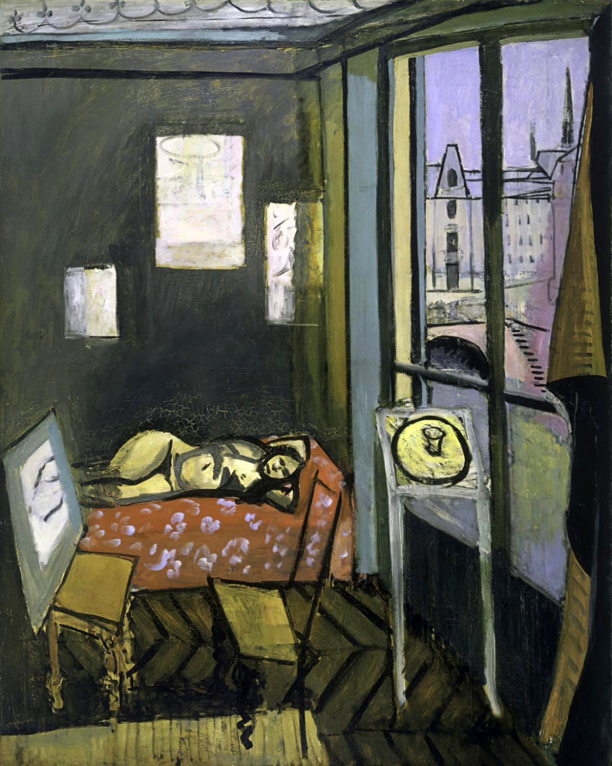 This image is Henri Matisse's painting "Studio, Quai Saint-Michel" from 1916. It shows a somber interior scene with a reclining figure, likely his model Laurette, on a couch with a red patterned cover. The room is defined by dark vertical and horizontal lines, with dark, muted colors. On the left, artworks are faintly visible against the shadowy wall. A large window opens to a view of Paris, with the Palais du Justice and Sainte Chapelle visible in the distance, bathed in a soft lavender hue. The painting captures the blend of the interior studio space with the exterior urban landscape, unified through Matisse's window motif. Shadows on the figure and the wall indicate reworking by the artist, and a propped canvas on a chair suggests the presence of the artist himself. The work is a study in the integration of representational and abstract elements, reflecting the complex relationship between the artist's inner world and the external environment.